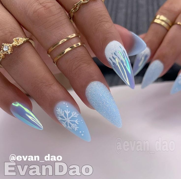 Chic Icy Blue Stiletto Nails: Intricate Snowflakes and Frosty Gradient.