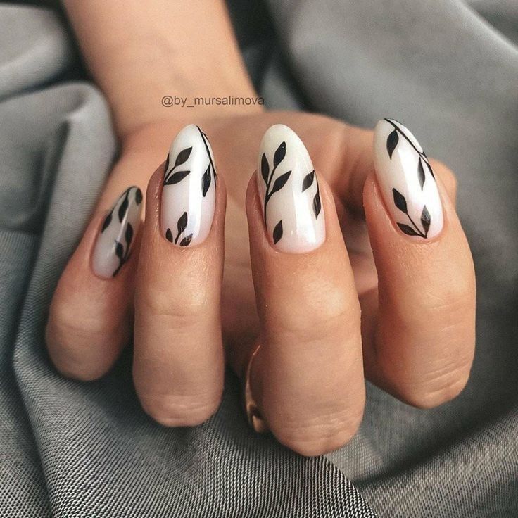 Sophisticated Almond-Shaped Nail Design with White and Black Leaf Patterns.