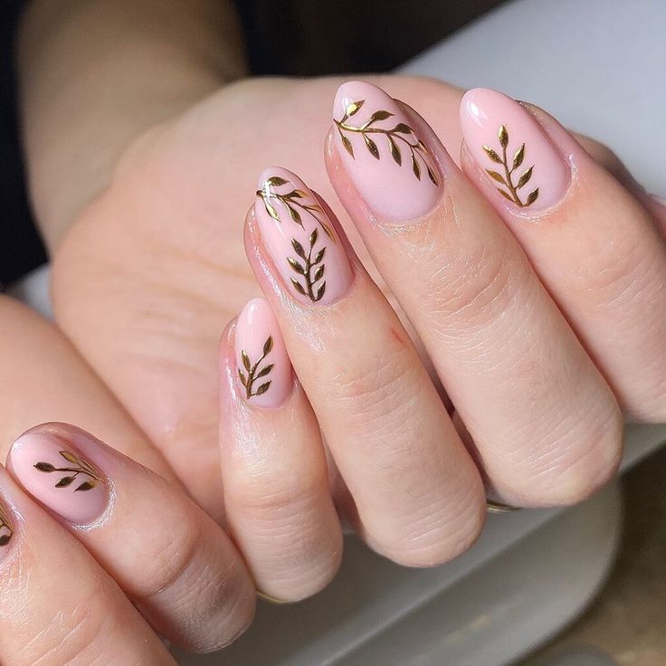 Sophisticated Soft Pink Nail Design with Delicate Golden Leaf Accents.