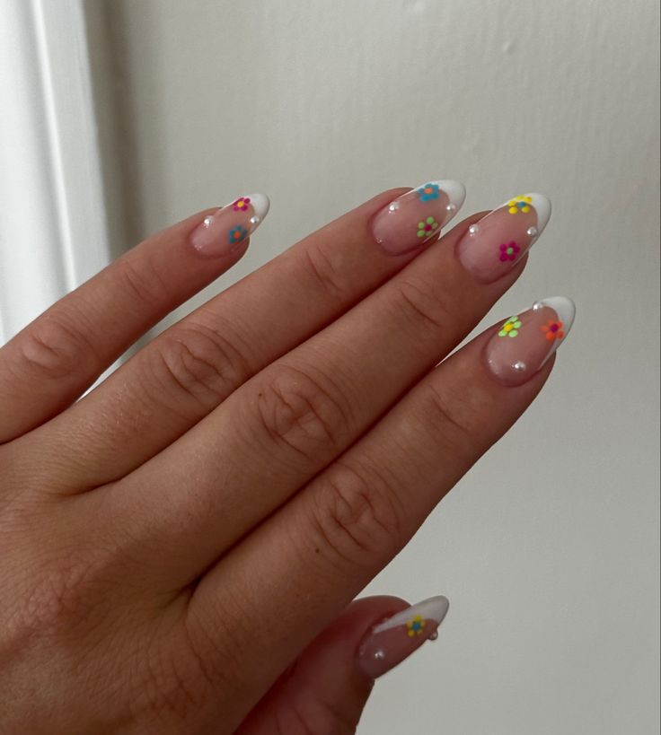 Chic French Tip Nails with Colorful Floral Accents for a Playful, Summery Look