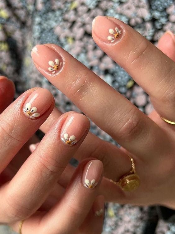 Charming Floral Nail Design with Soft Nude Base and Daisies for a Spring-Inspired Look.