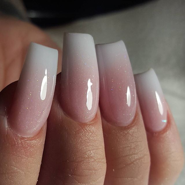 Elegant Ombre Nail Design: Soft White to Pink Gradient with Glossy Finish and Sparkles.