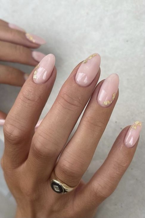 Elegant Almond-Shaped Nails with Sheer Pink Polish and Glamorous Gold Flakes.