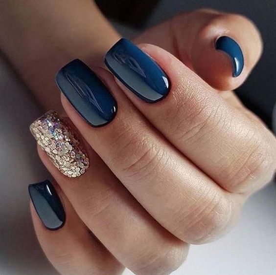 Chic Deep Navy Nail Design with Sparkly Gold Accent for Sophisticated Glamour.