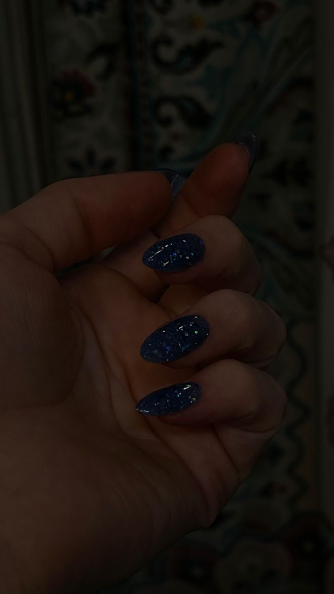 Elegant Deep Blue Oval Nail Design with Shimmering Silver Glitter.