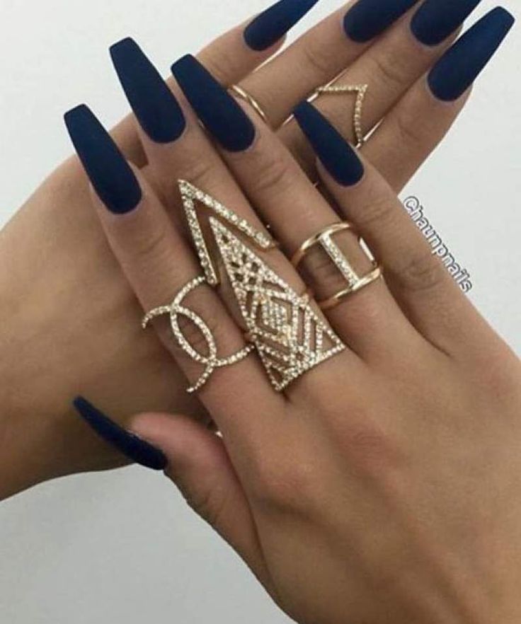 Sophisticated Matte Navy Blue Nails Accentuated by Intricate Gold Rings for a Chic Statement Look.