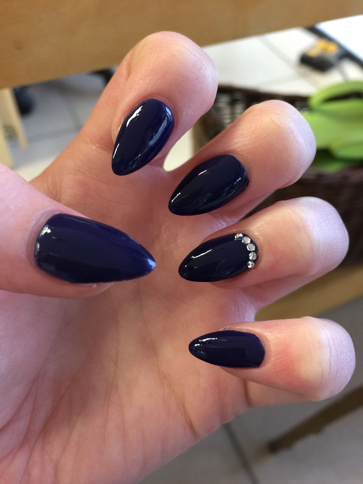 Elegant Dark Navy Almond-Shaped Manicure with Rhinestone Accent.