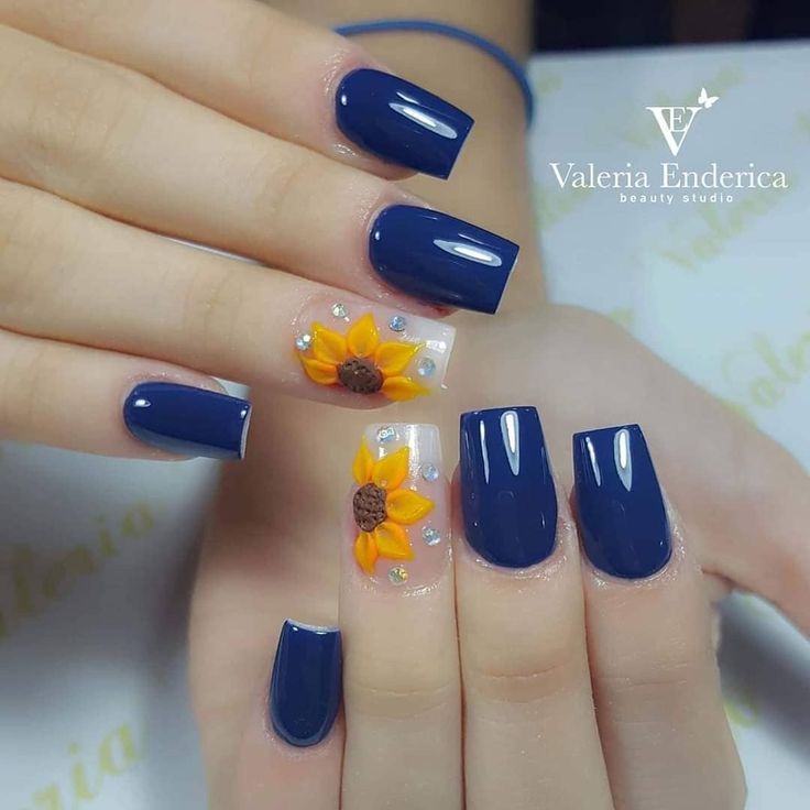 Bold and Sophisticated Navy Blue Nail Design with Sunflower Accents and Sparkling Rhinestones.