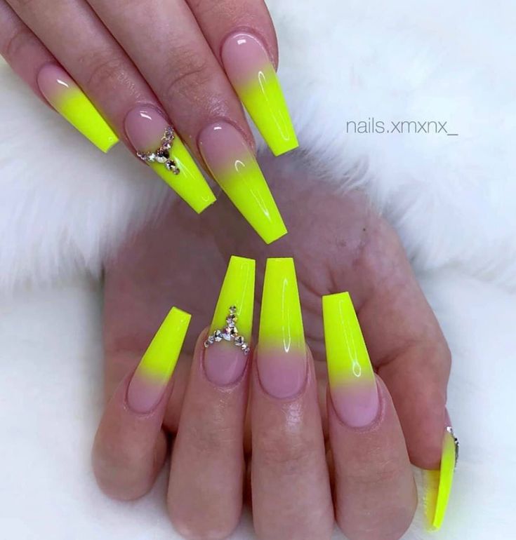 Striking Neon Yellow Ombre Nails with Rhinestone Accents for a Bold Statement.