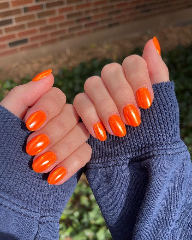 Eye-Catching Glossy Orange Oval Nail Design: A Stylish Touch to Any Outfit.