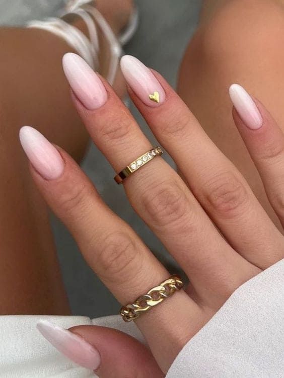 Chic Ombre Nail Design with Soft Pink Gradients and Gold Heart Accents.