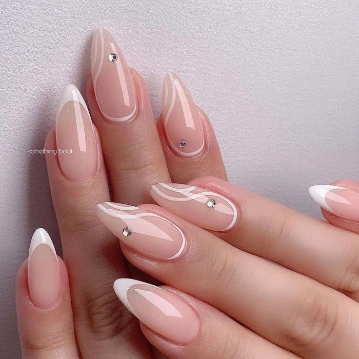 Sophisticated Almond-Shaped Nails: A Chic Blend of Soft Nude, White Tips, and Sparkling Rhinestones.