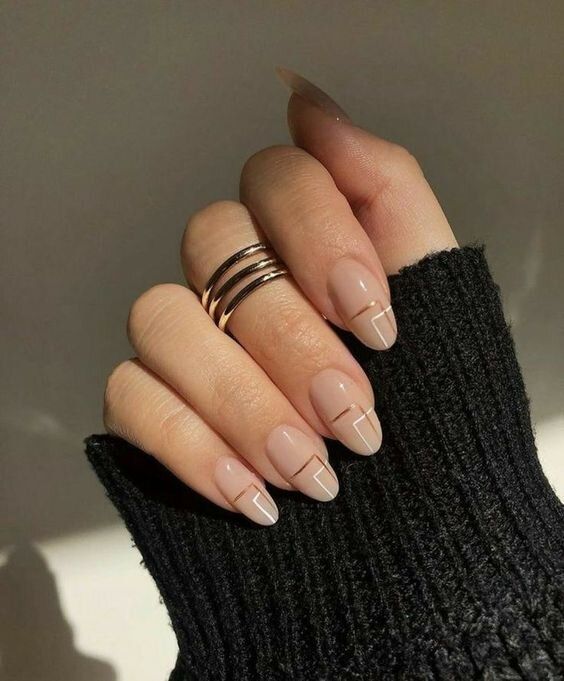 Chic Nude Almond Nails with Minimalist White Geometric Accents and Gold Rings.