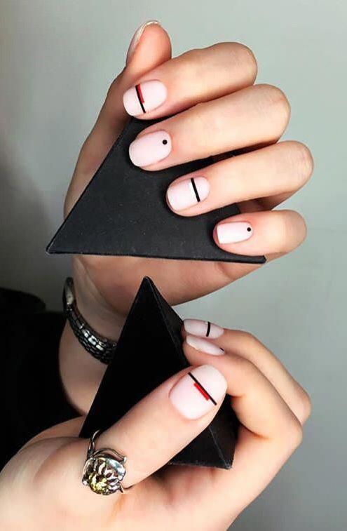 Minimalist Geometric Nail Design in Pastel Pink with Bold Black and Red Accents.