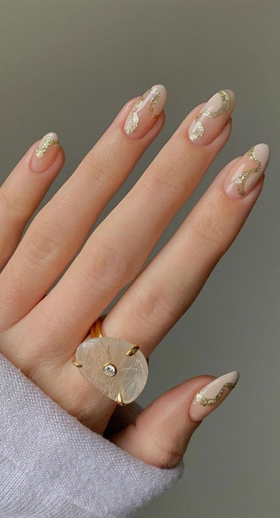 Chic Elegant Nude Nail Design with Gold Swirls and Statement Ring.