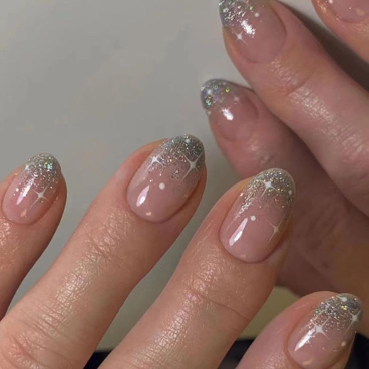 Chic Nude and Glitter Nail Design with Whimsical Accents