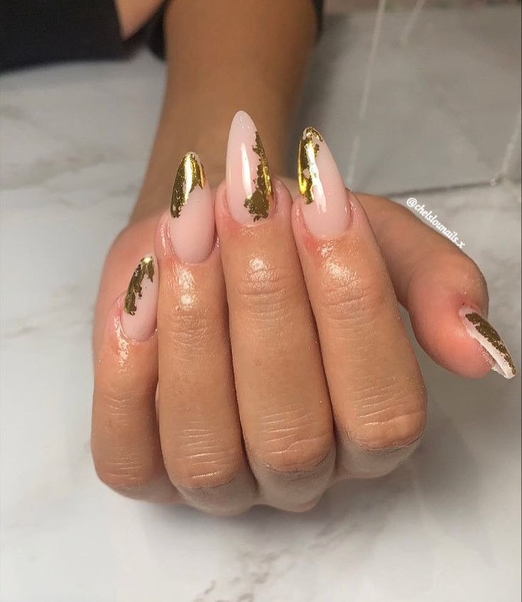 Sophisticated Almond-Shaped Nail Design with Nude Base and Striking Gold Accents.