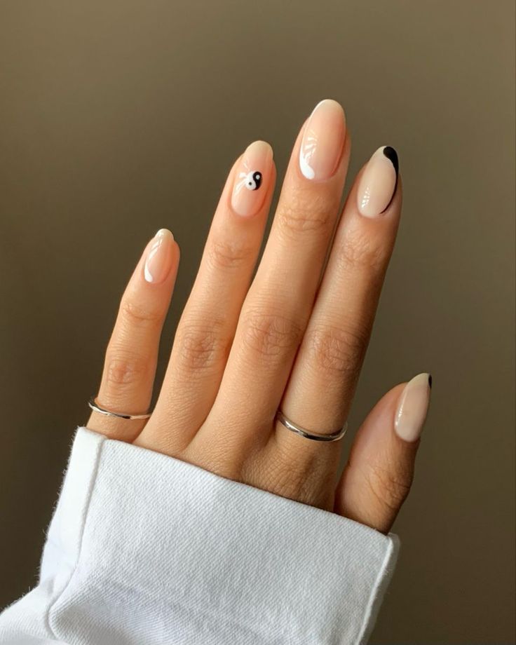 Chic Nail Design: Nude Base with Pointed Tips and Minimalist Yin-Yang Accents.