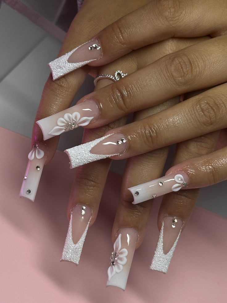 Sophisticated Long Square Nails with Intricate White Florals, Glitter Tips, and Rhinestone Accents