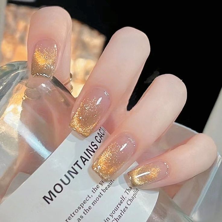 Elegant Glittery Ombre Nails: A Chic Transition from Nude to Shimmering Gold