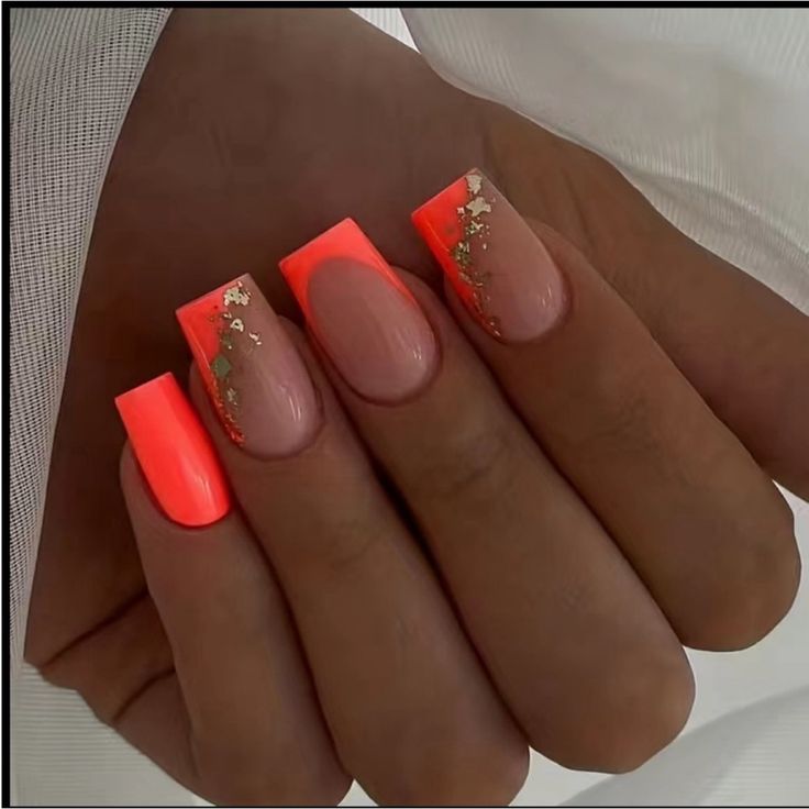 Bold Neon Orange and Soft Nude Nail Design with Glittering Gold Flakes for a Sophisticated Statement.