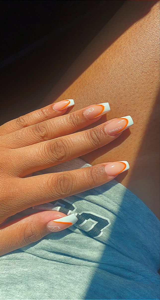 Elegant French Manicure with Peach Tips, Vibrant Orange Accent, and Subtle Floral Art.