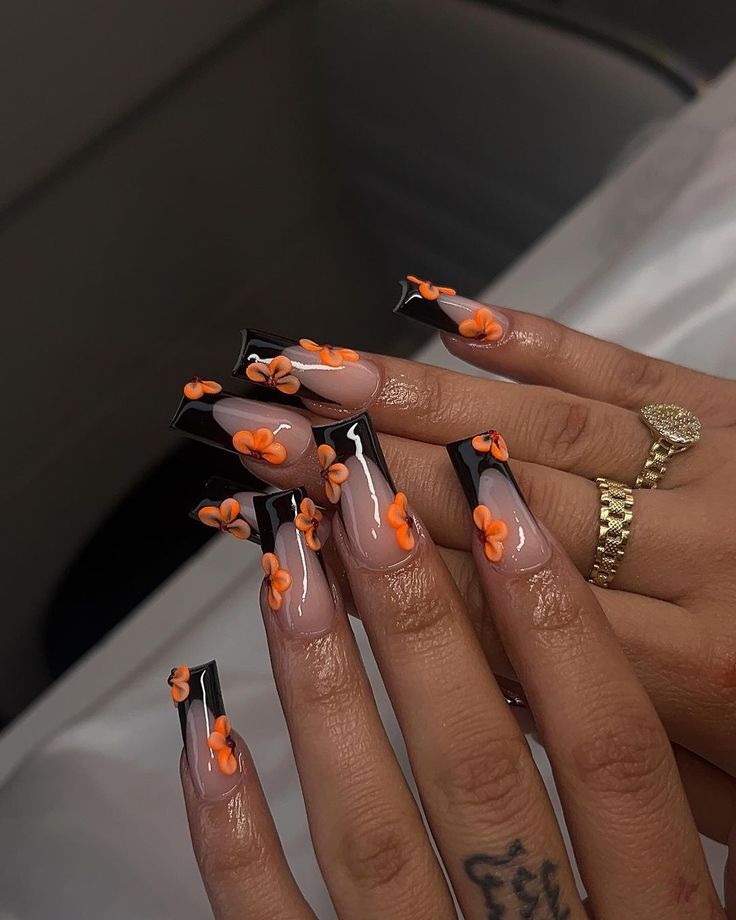 Vibrant Floral Nail Design with Contrasting Nude and Glossy Black Tips