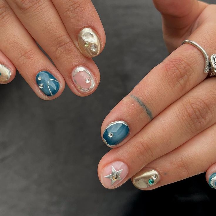 Elegant and Creative Vibrant Nail Design with Deep Blue, Shimmering Gold, and Gemstone Embellishments.