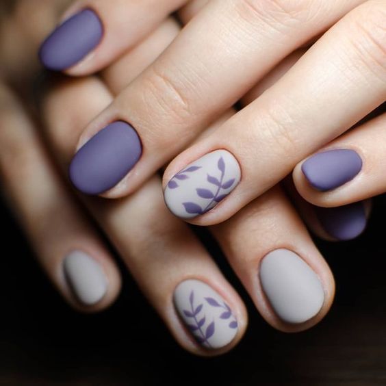 Elegant Matte Nail Design in Purple and Gray with Delicate Leaf Patterns.