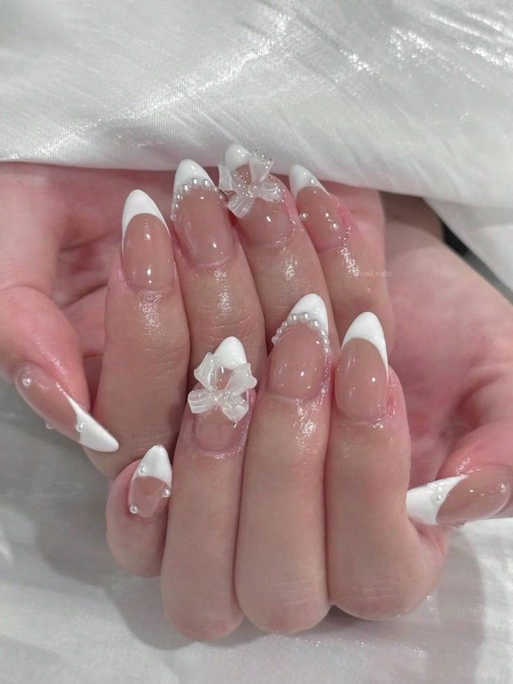 Chic French Tip Nails with Floral Accents and Pearl Embellishments for a Sophisticated Look.