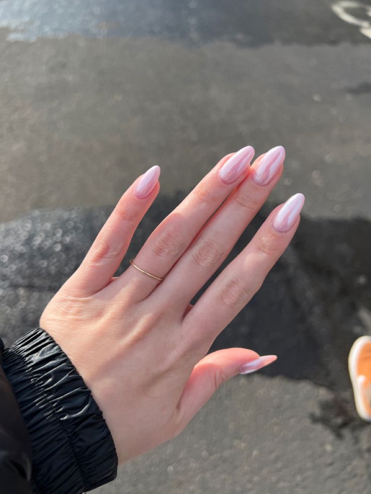 Sophisticated Pastel Pink Almond-Shaped Nails with Glossy Finish and Minimalistic Jewelry.