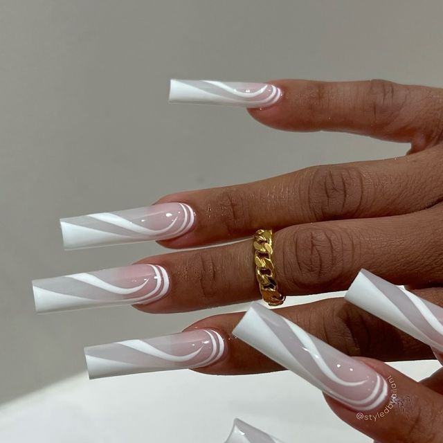 Elegant Long Nails with White and Soft Pink Swirls, Enhanced by Glossy Finish and Gold Ring.