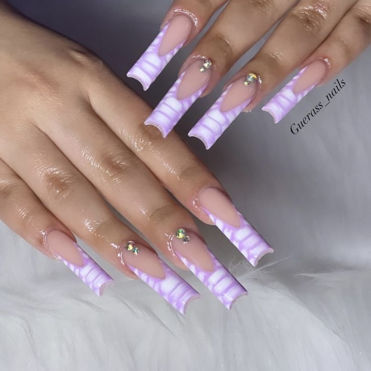 Glamorous Stiletto Nail Design: Soft Pink Base with Lavender Accents and Sparkling Embellishments.