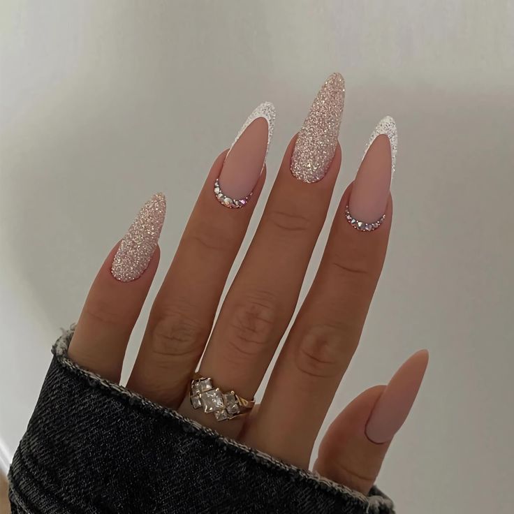 Glamorous Elongated Nude and Glitter Nail Art with Elegant Rhinestone Accents.