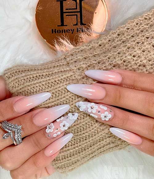 Chic Ombre Nail Design with Floral Accent and Stylish Rings.