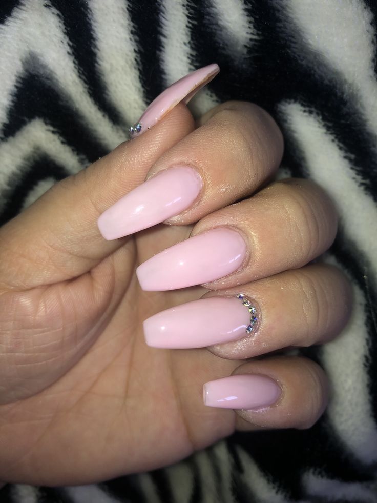 Modern Elegant Pink Almond Nails with Glossy Finish and Rhinestone Accents.