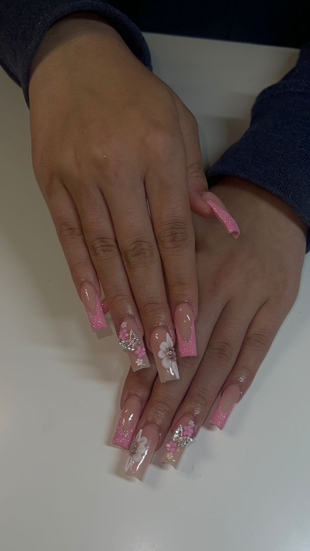 Elegant Floral Nail Design in Soft Pink and Nude with Glittery Tips.