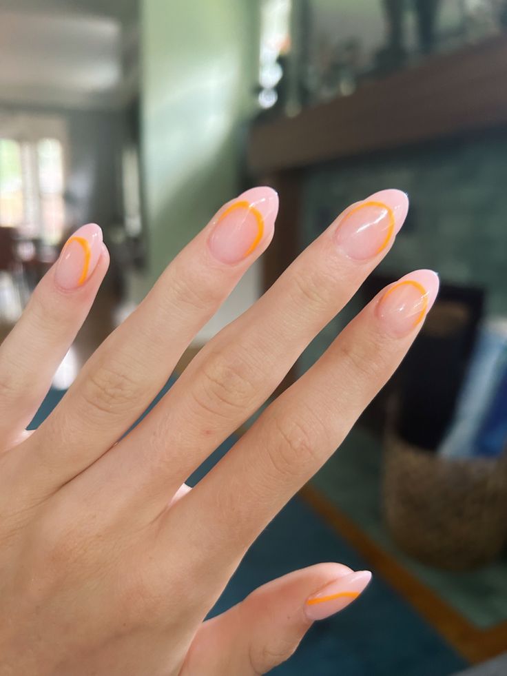 Chic Nail Design: Soft Pink Base with Vibrant Orange Tips for a Fresh Aesthetic.