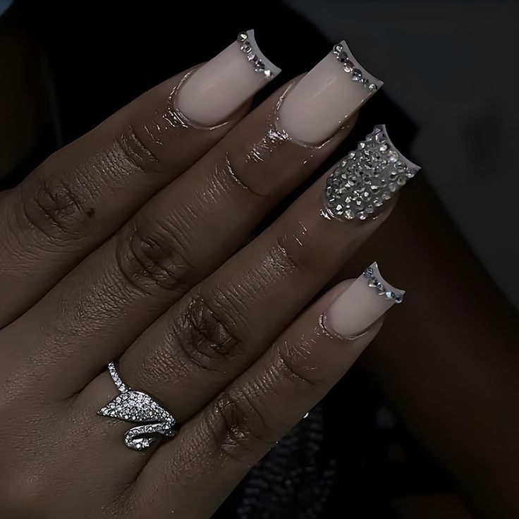 Sophisticated Nail Design: Nude and Shimmering Tips with Rhinestone Accents.