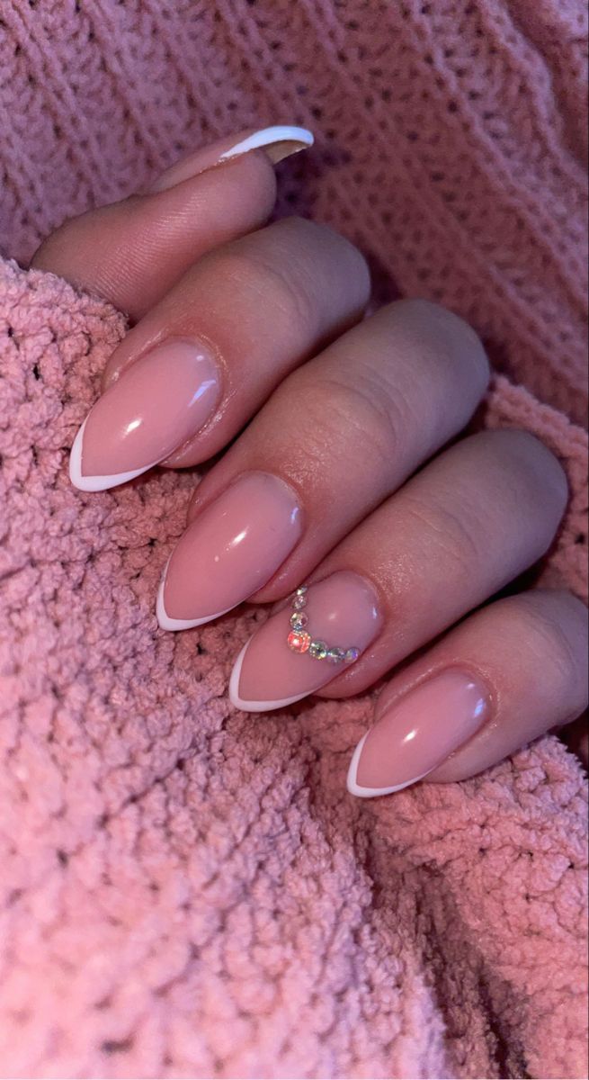 Chic Soft Pink and White Nail Design with Gemstone Accents for Elegant Occasions.