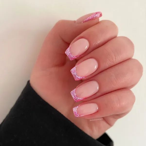 Elegant Chic Nail Design with Nude Base and Shimmering Pink Glitter Tips.