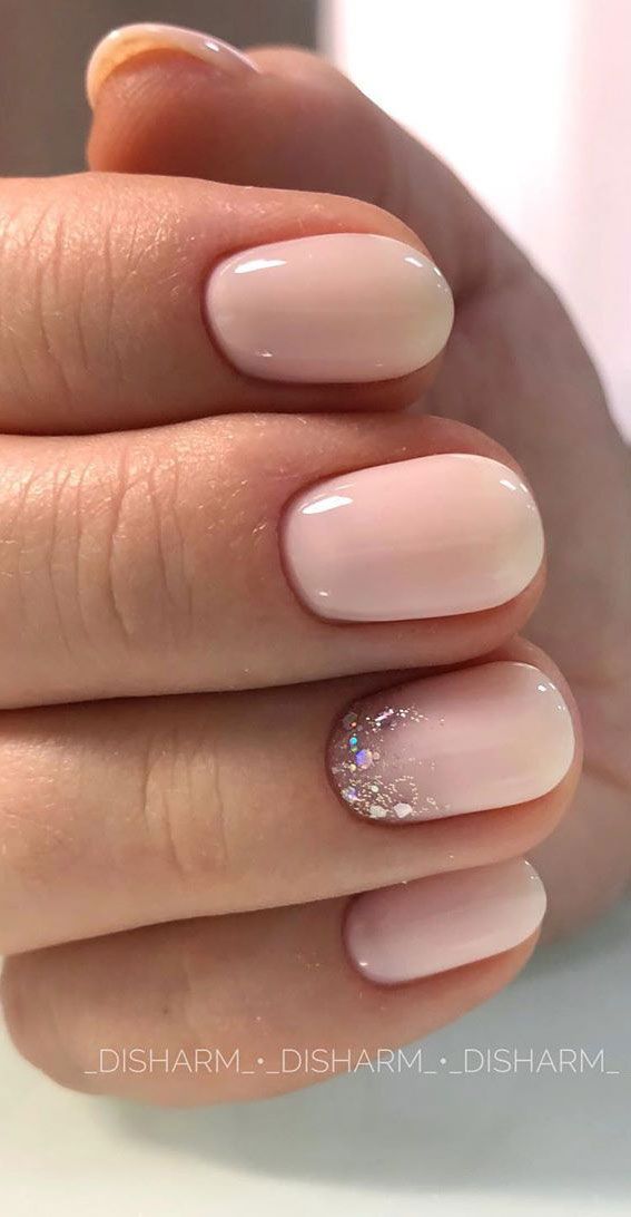 Sophisticated Nude Manicure with Glossy Finish and Subtle Glitter Accent