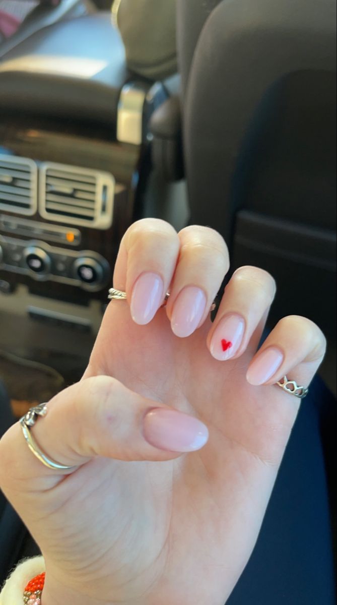 Charming Pink Nails with Playful Heart Accent and Dainty Rings.