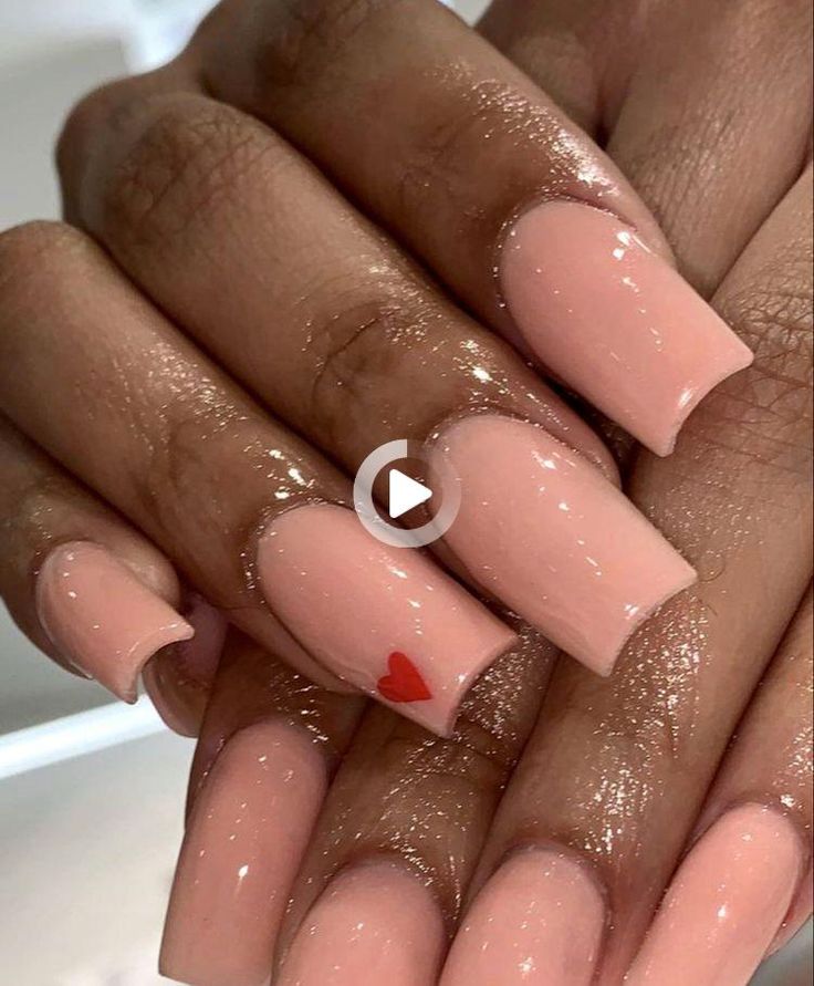 Elegant Glossy Nude Nails with a Playful Red Heart Accent.