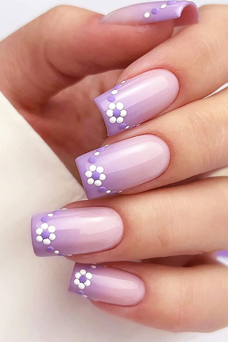 Chic Purple Ombre Nails with Delicate White Floral Accents for a Feminine Touch.