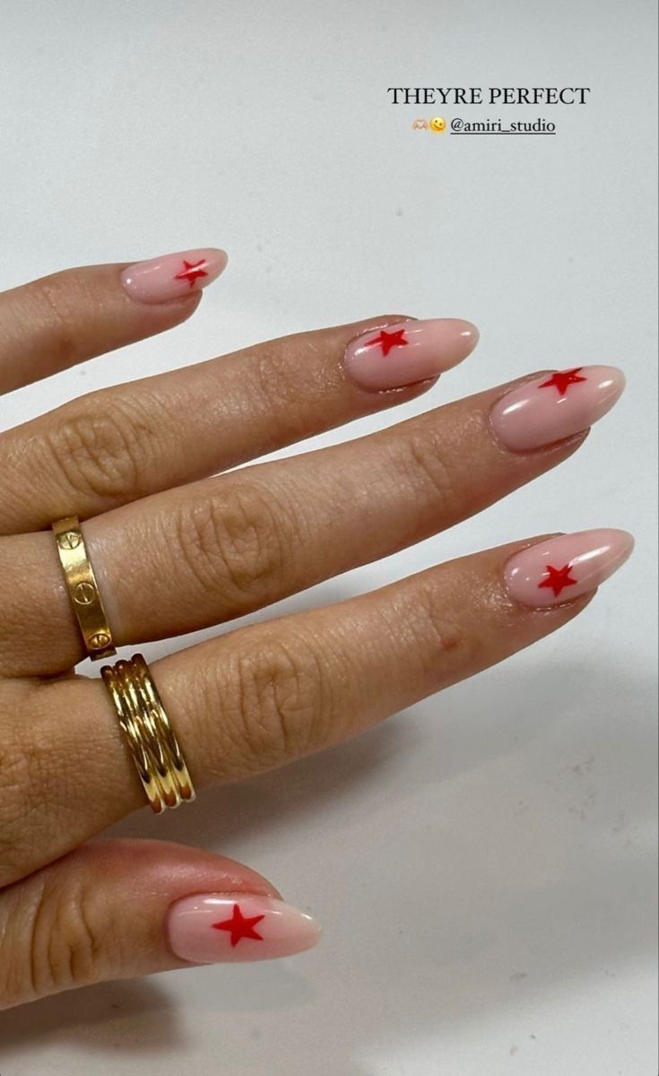 Chic Almond-Shaped Nails: Soft Pink Base with Vibrant Red Star Accents.