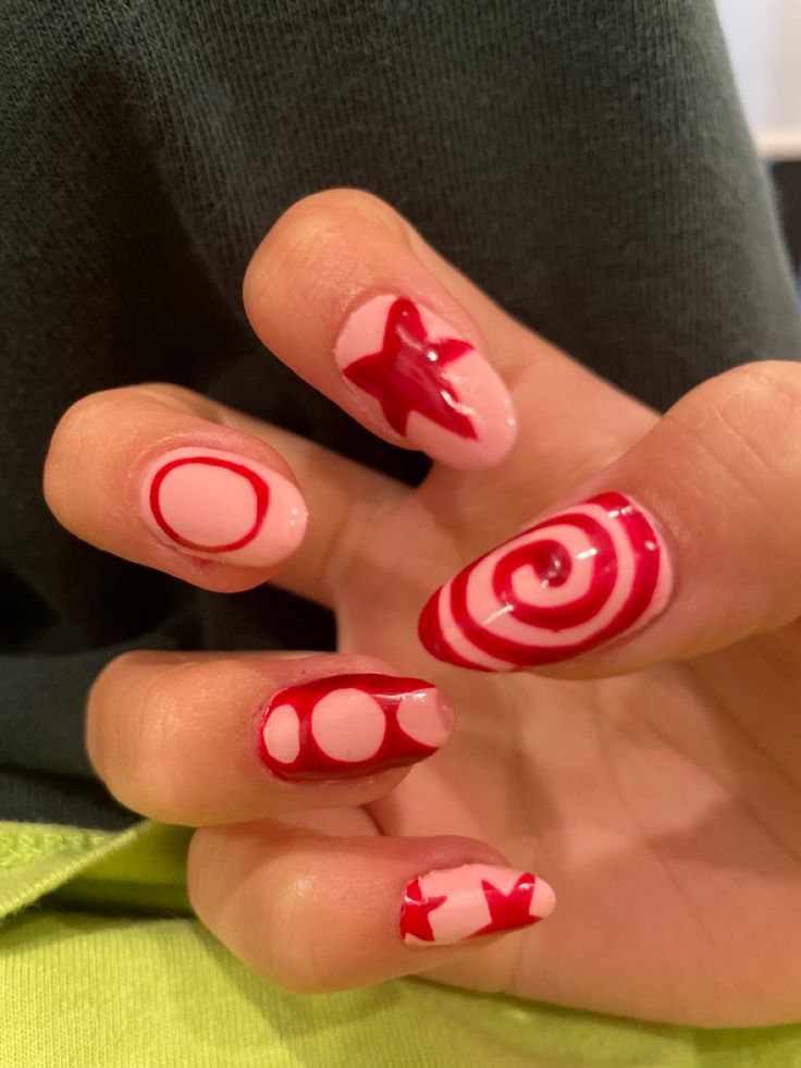 Whimsical Geometric Nail Art: Bold Red Swirls on Soft Pink Background