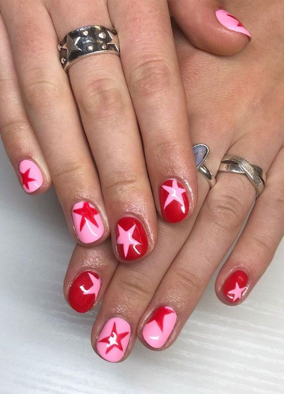 Bold and Playful Red and Pink Nail Art with Elegant Star Designs.