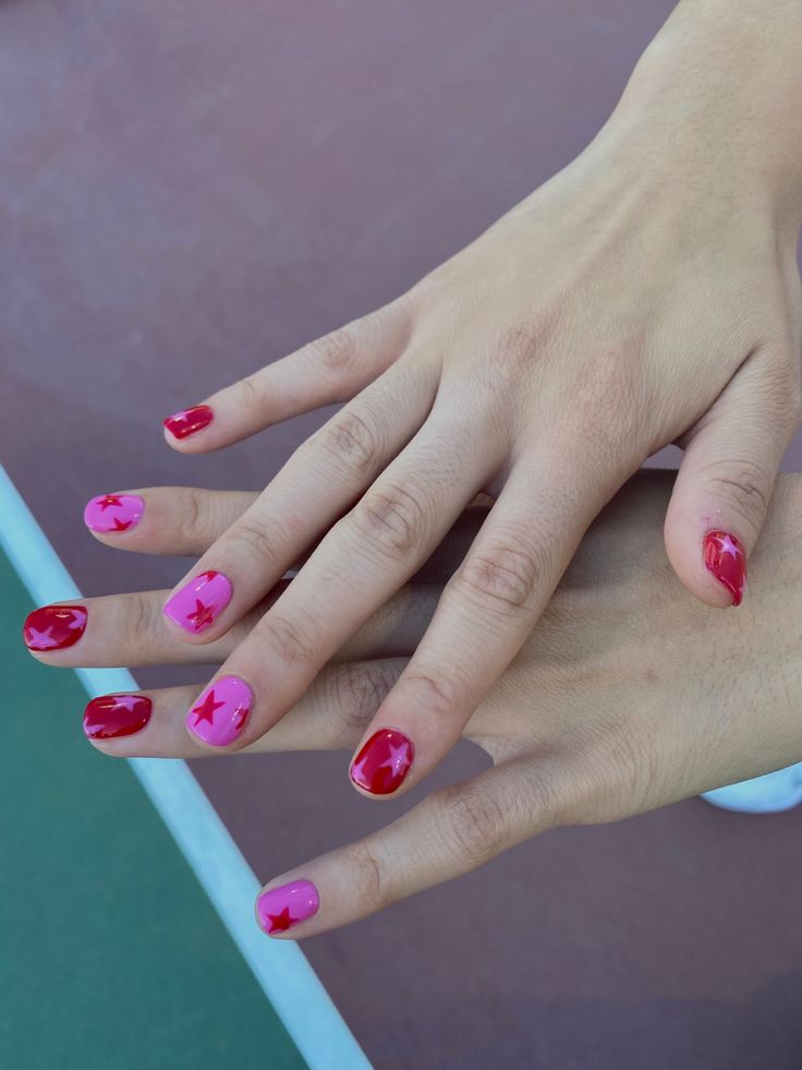 Whimsical Nail Design: Playful Pink and Red with Star Motifs for a Bold Individual Statement