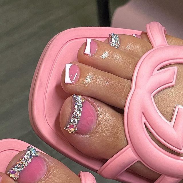 Chic Pink Pedicure with Glossy White Tips and Rhinestone Accents, Perfectly Paired with Trendy Sandals.